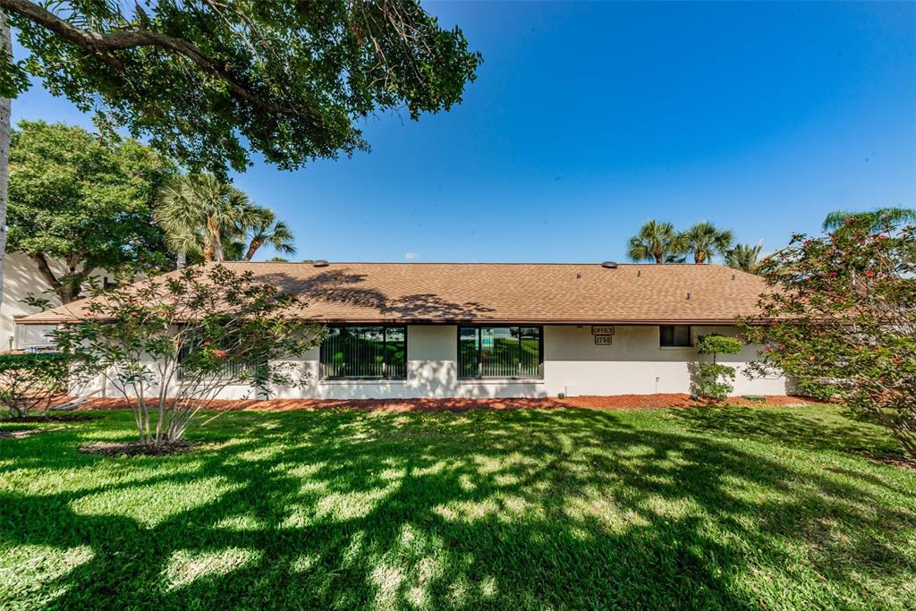 2522 Pine Ridge Way South, Unit A2 Palm Harbor, FL 34684 - Photo 22 of 34 a front view of a house with a garden