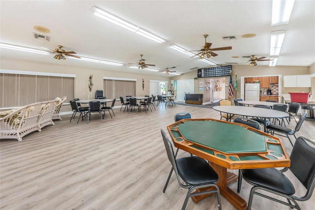 2522 Pine Ridge Way South, Unit A2 Palm Harbor, FL 34684 - Photo 26 of 34 a dining hall with stainless steel appliances granite countertop a stove a couches a dining table and chairs with wooden floor