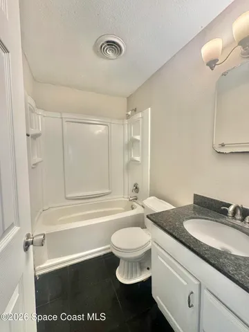 a view of a hallway with wooden floor and closet area