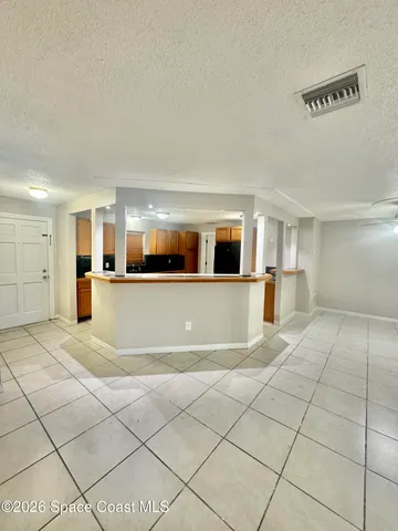a view of a livingroom with an empty space and a window