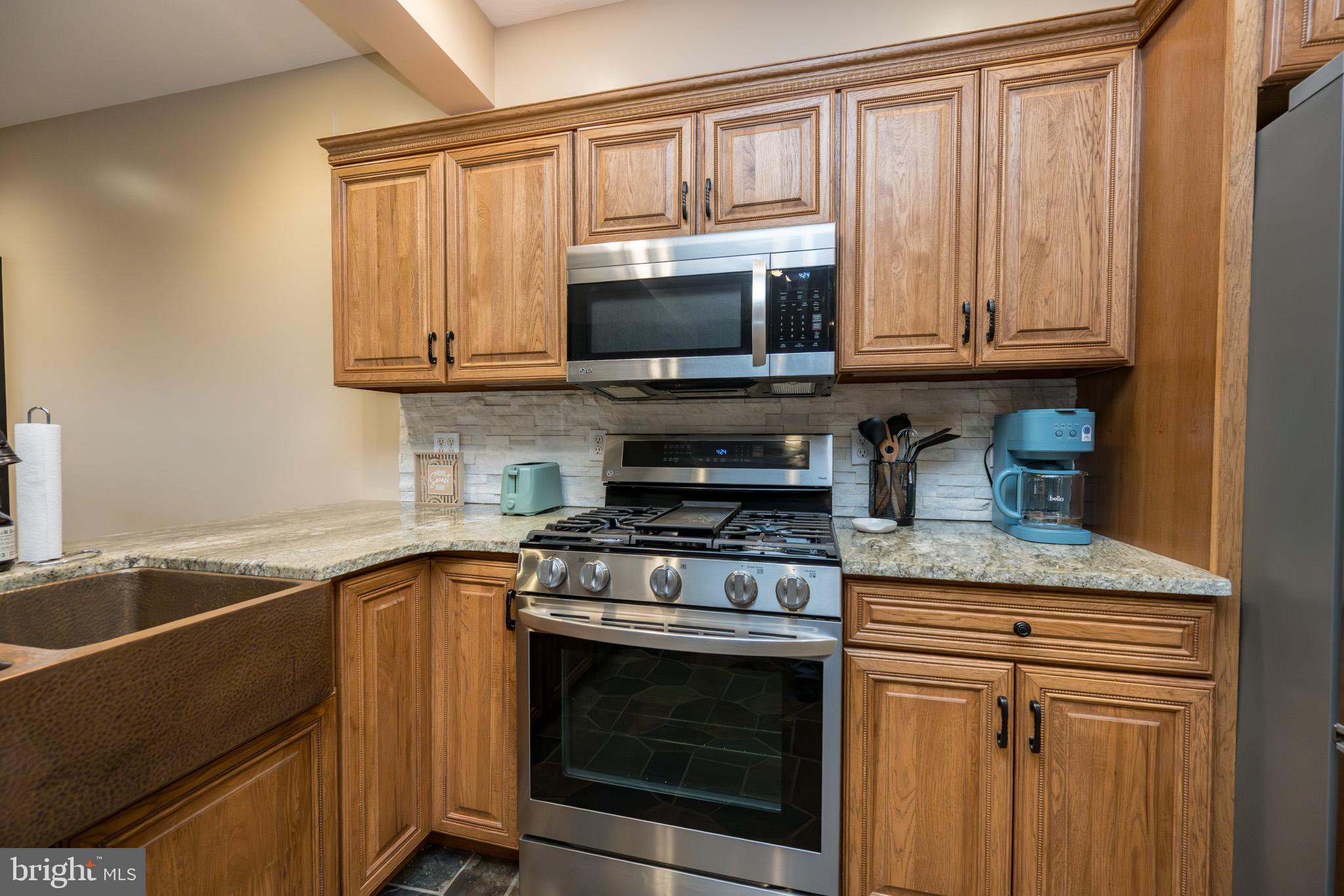 147 Marsh Hill Road McHenry, MD 21541 - Photo 9 of 60 a kitchen with stainless steel appliances granite countertop a stove microwave and cabinets