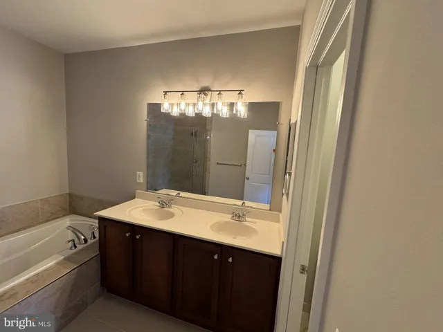 a bathroom with a tub sink and mirror