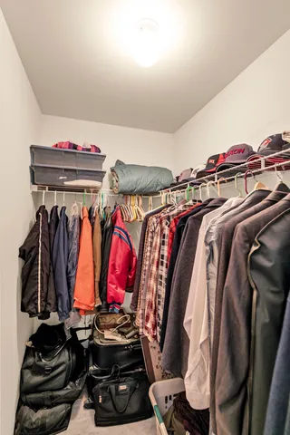 a view of walk in closet with clothes and shoes