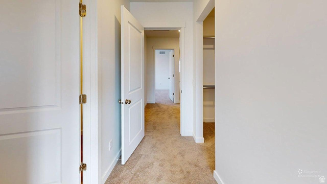 783 Pheasantbrook Drive, Unit 2A Centerville, UT 84014 - Photo 32 of 41 Carpeted hallway featuring white walls and white two-panel doors with brass hardware