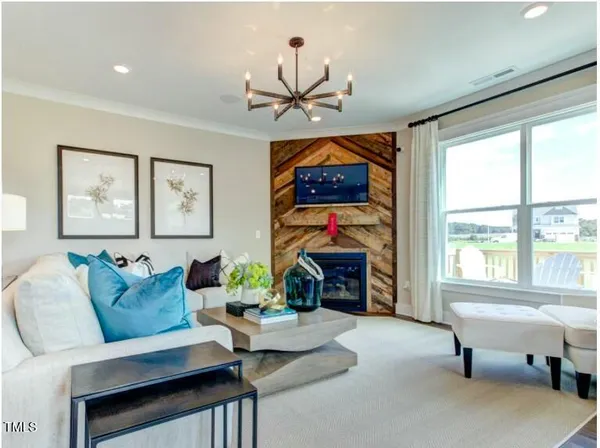 a living room with furniture a fireplace and a large window
