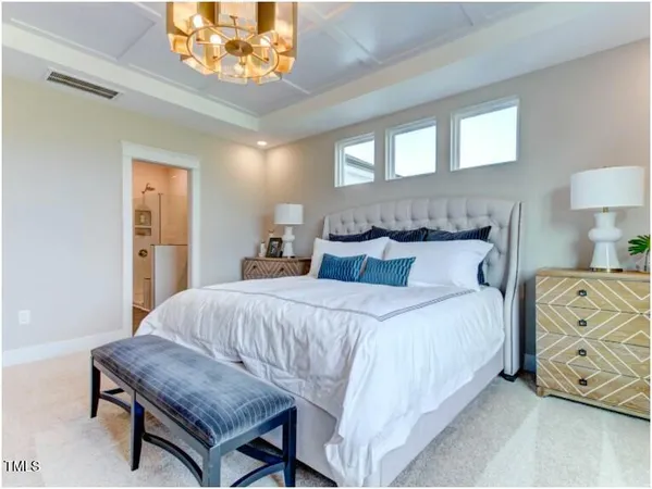 a bedroom with a bed a dresser and window
