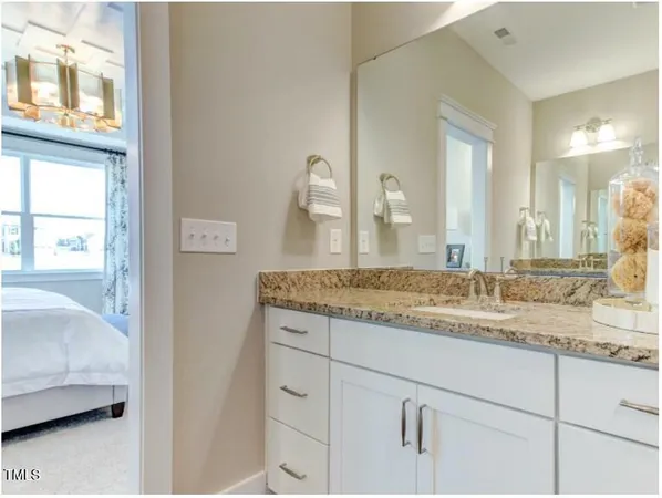 a bathroom with a granite countertop sink and a mirror