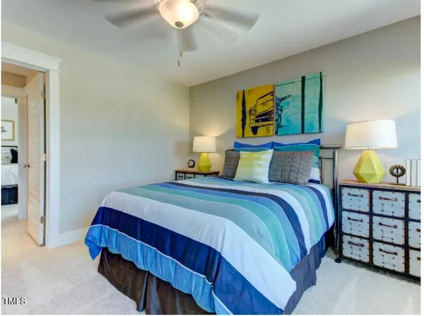 a bedroom with a bed a lamp and fan
