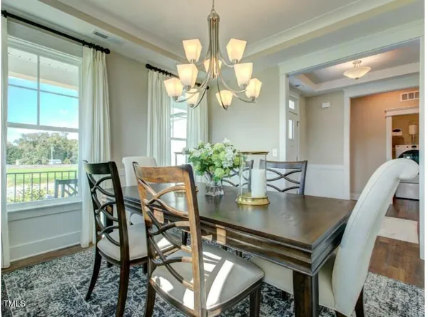 a view of a dining room with furniture and a chandelier