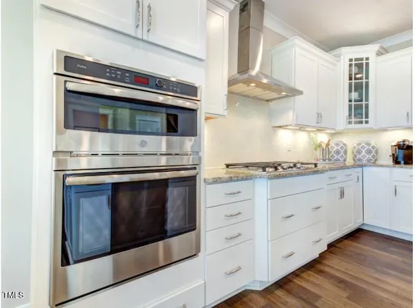 a kitchen with granite countertop cabinets stainless steel appliances and wooden floor