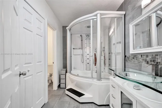 a bathroom with a sink a toilet a mirror and a tub