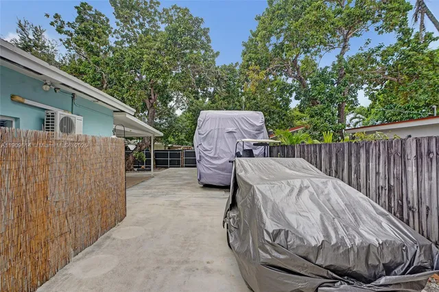 a view of a patio with couches table and chairs under an umbrella