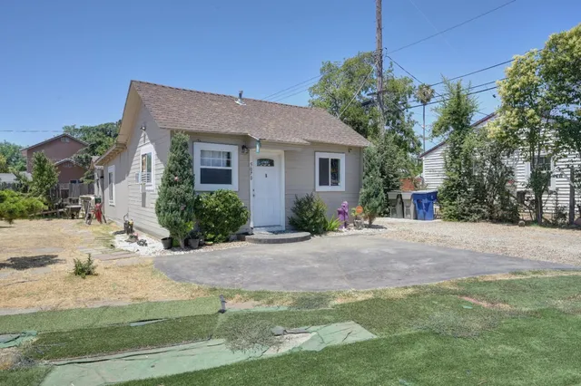 a front view of a house with a yard and potted plants