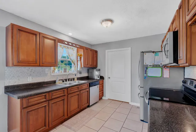 a kitchen with stainless steel appliances granite countertop a sink stove and cabinets