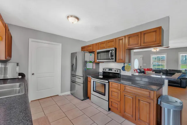 a kitchen with stainless steel appliances granite countertop a stove a sink and a refrigerator