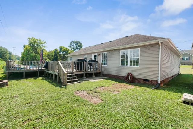 a view of a house with backyard and sitting area