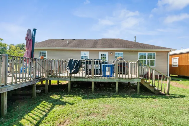 a view of a house with a yard deck and a patio