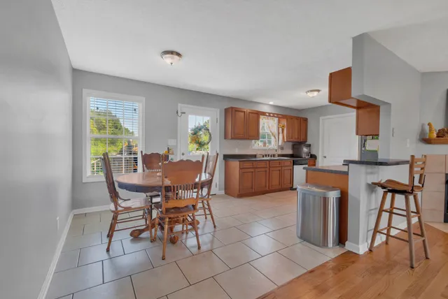 a view of a dining room with furniture and a kitchen view