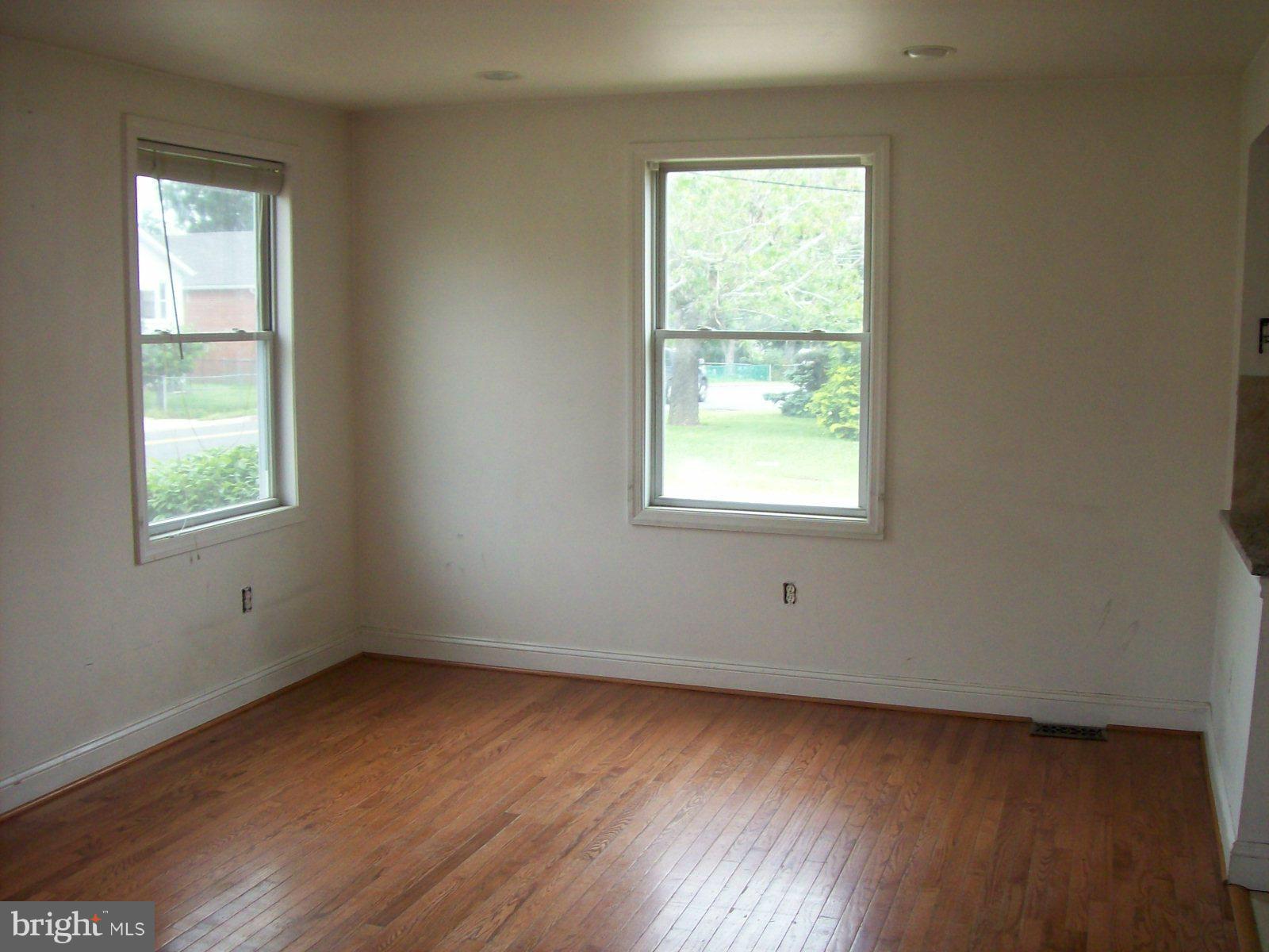 6921 Sollers Point Road Dundalk, MD 21222 - Photo 3 of 4 an empty room with wooden floor and windows