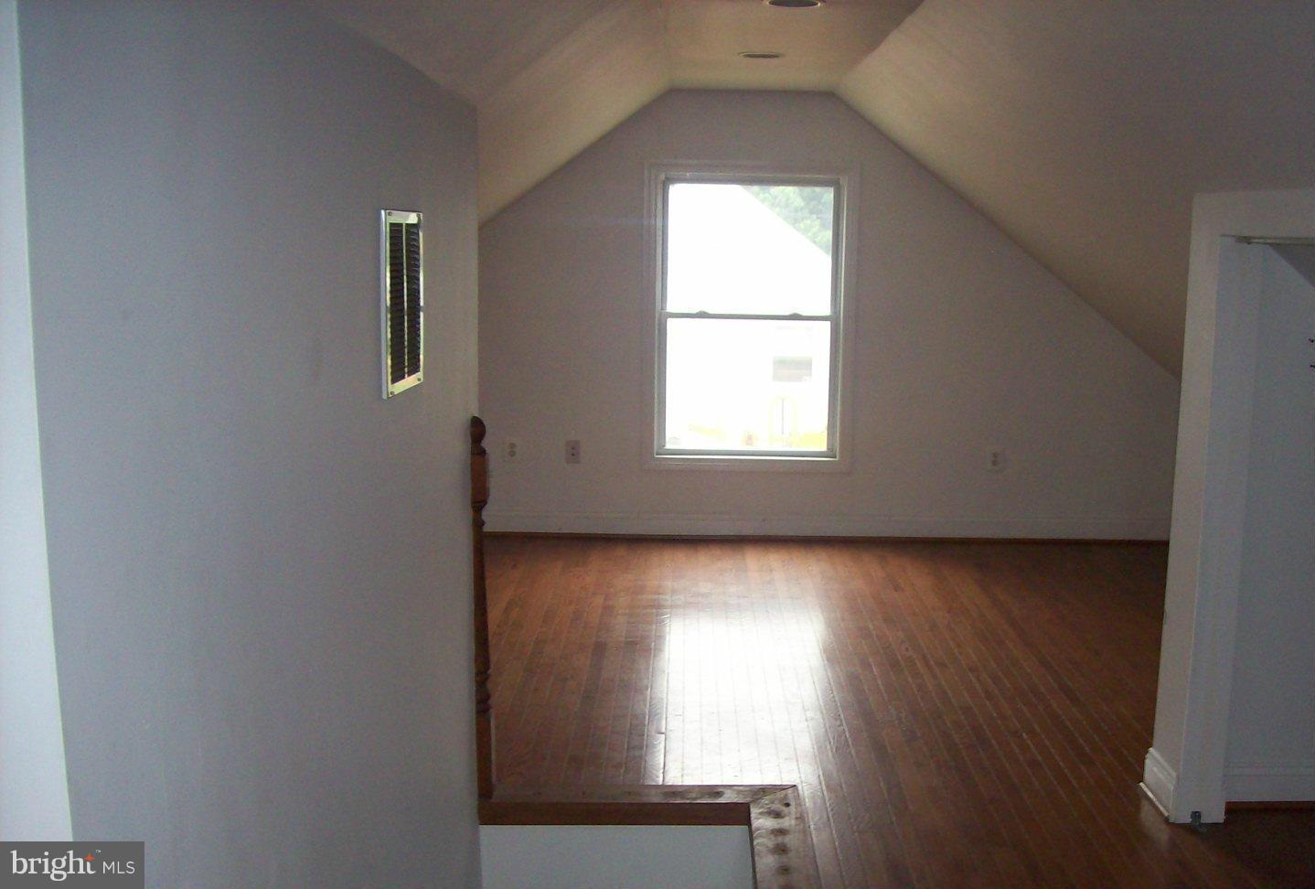 6921 Sollers Point Road Dundalk, MD 21222 - Photo 4 of 4 an empty room with wooden floor and windows