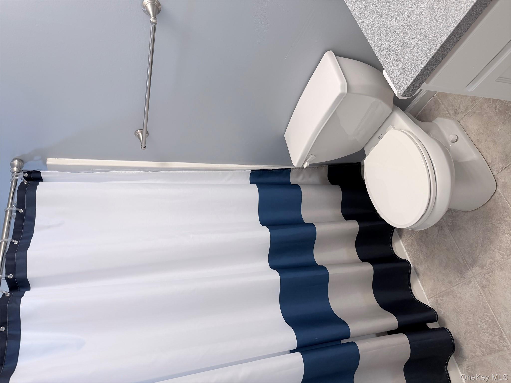 1043 Roosa Gap Road Pine Bush, NY 12566 - Photo 19 of 20 Full bath featuring curtained shower, vanity, and light tile patterned flooring