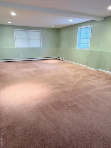 a view of an empty room with a kitchen and a window