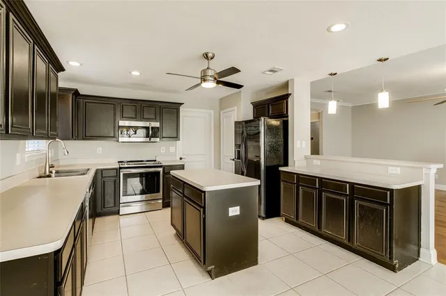 a kitchen with stainless steel appliances granite countertop a stove a sink and a refrigerator