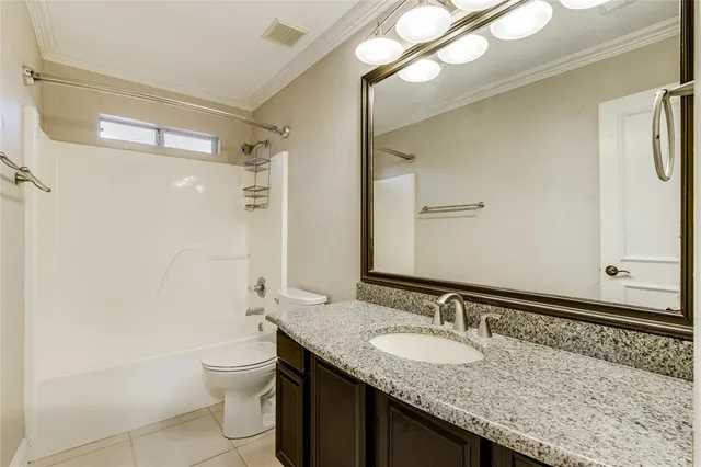 a bathroom with a granite countertop sink a toilet and a shower