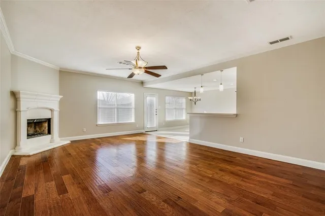 a view of an empty room with a fireplace and wooden floor