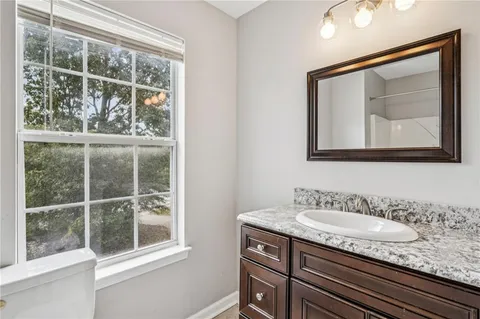 a bathroom with a granite countertop sink a mirror and a window