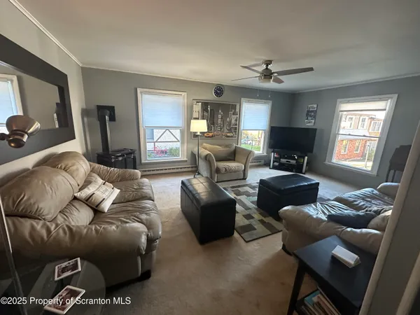 a living room with furniture ceiling fan and a window