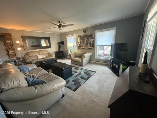 a living room with furniture a flat screen tv and a window