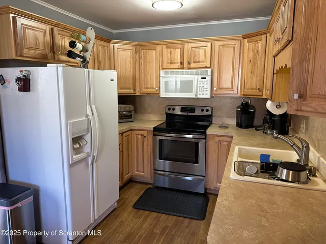 a kitchen with stainless steel appliances granite countertop a refrigerator a stove a sink and a microwave oven