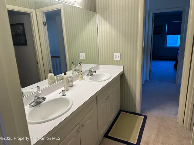 a en suite bathroom with a double vanity sink and a mirror