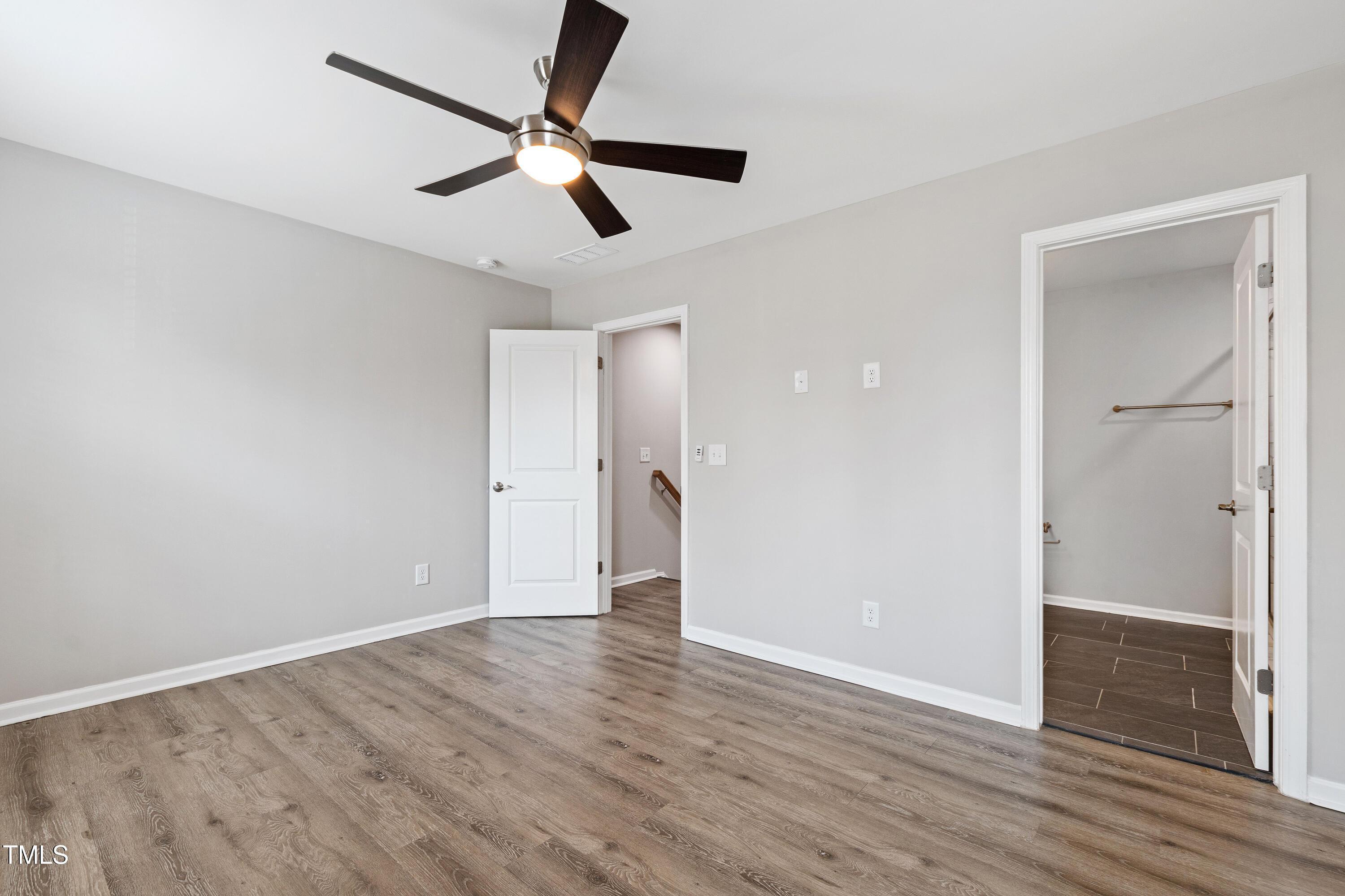 512 Spruce Street, Unit A Durham, NC 27703 - Photo 19 of 36 an empty room with wooden floor a ceiling fan and windows