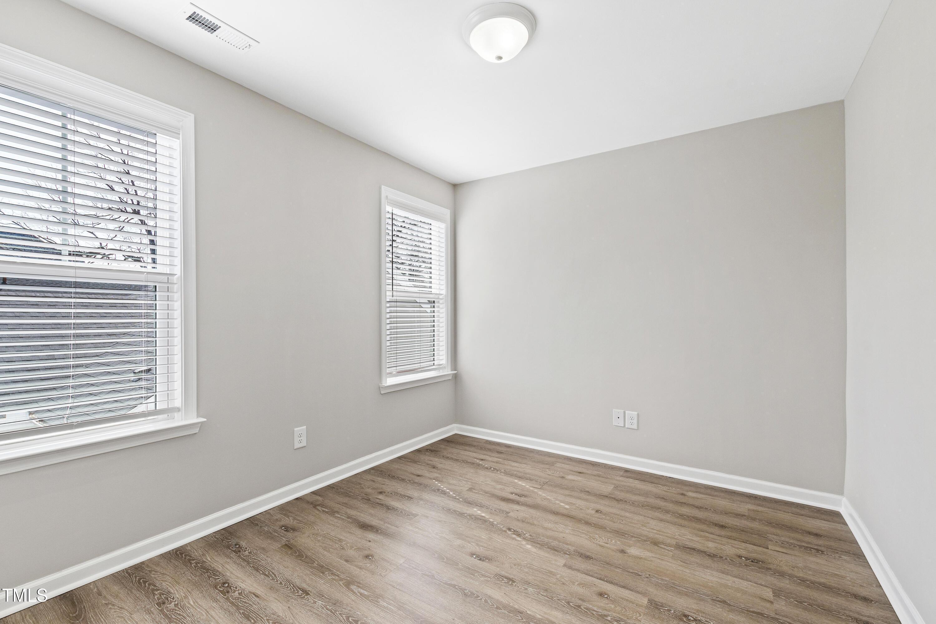 512 Spruce Street, Unit A Durham, NC 27703 - Photo 23 of 36 an empty room with wooden floor and windows
