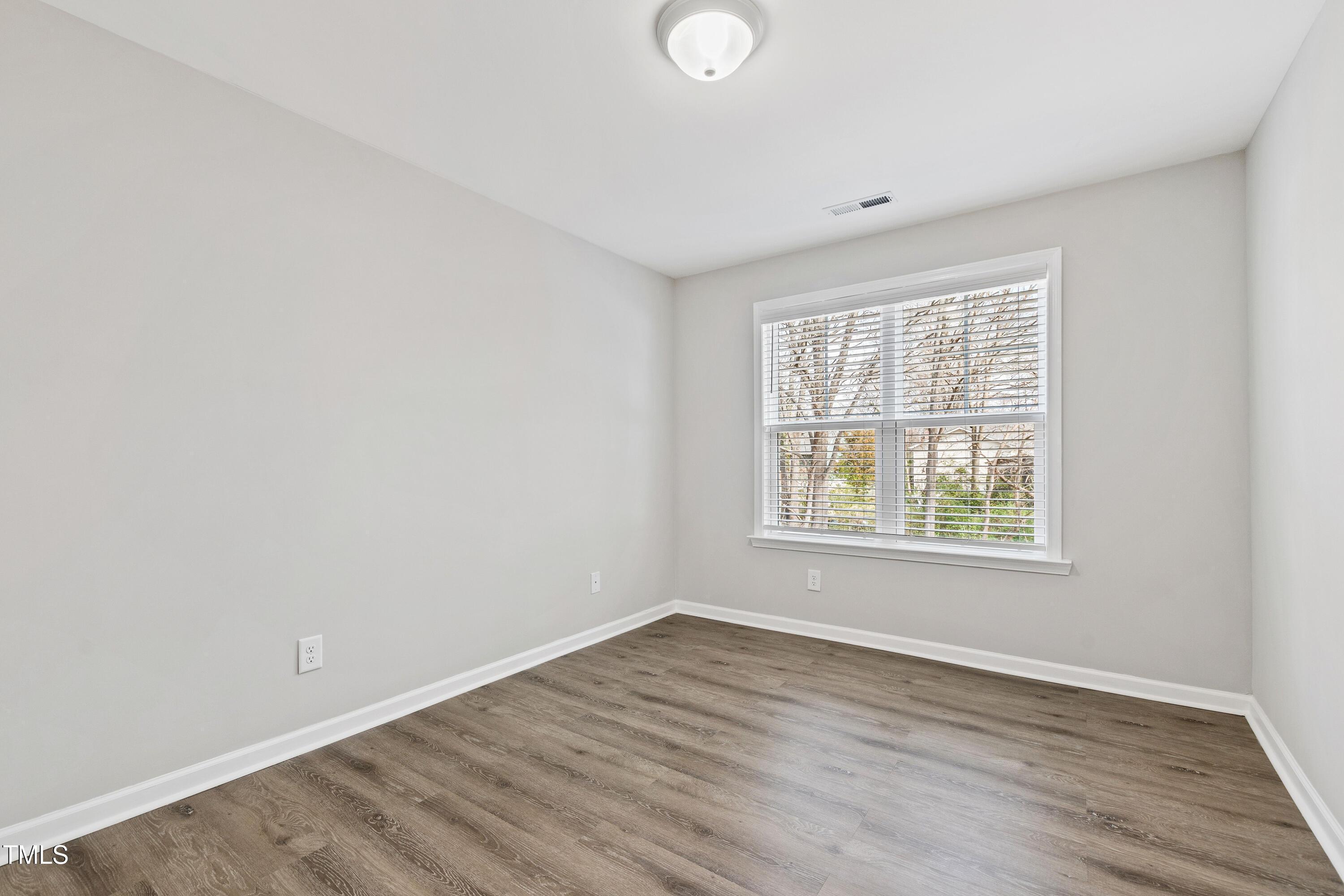 512 Spruce Street, Unit A Durham, NC 27703 - Photo 28 of 36 an empty room with wooden floor and windows