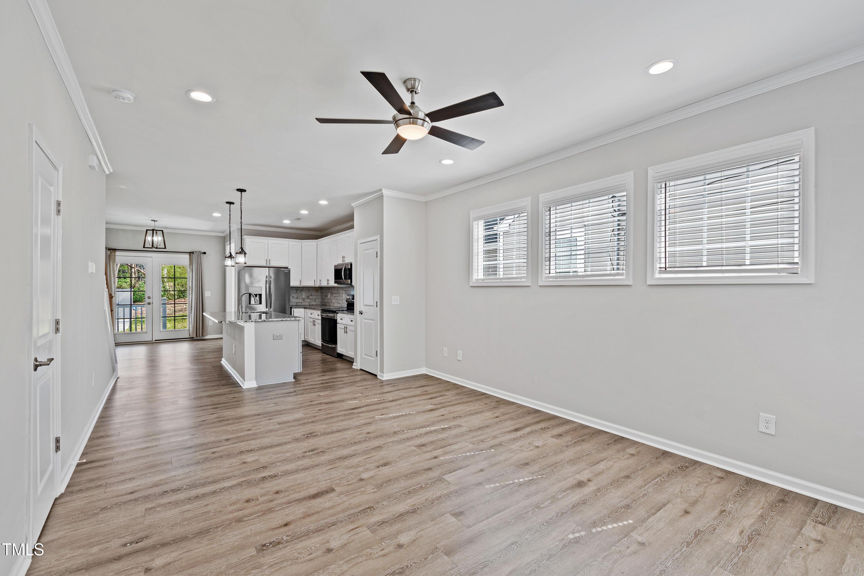 512 Spruce Street, Unit A Durham, NC 27703 - Photo 3 of 36 a view of a kitchen with a kitchen island wooden floor appliances and windows