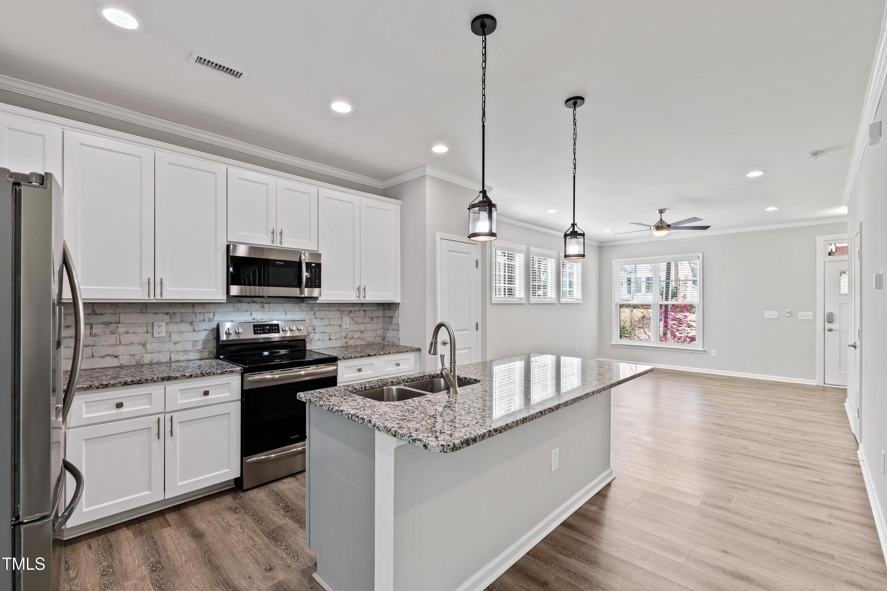 512 Spruce Street, Unit A Durham, NC 27703 - Photo 8 of 36 a kitchen with granite countertop a sink a counter top space stainless steel appliances and cabinets