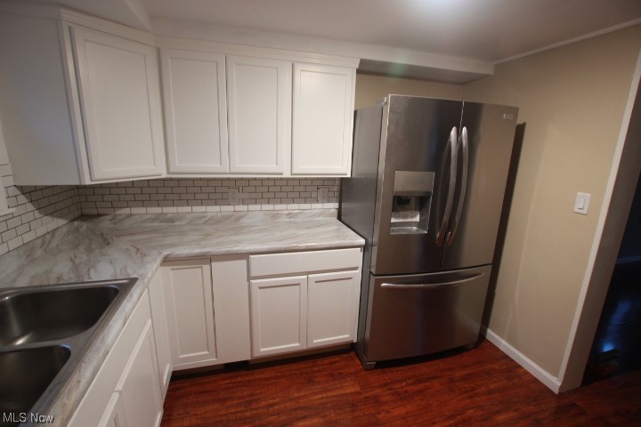 3606 Shelby Road Youngstown, OH 44511 - Photo 3 of 33 Kitchen with light stone counters, stainless steel fridge, dark hardwood / wood-style floors, white cabinets, and backsplash
