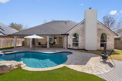a view of a house with swimming pool and sitting area