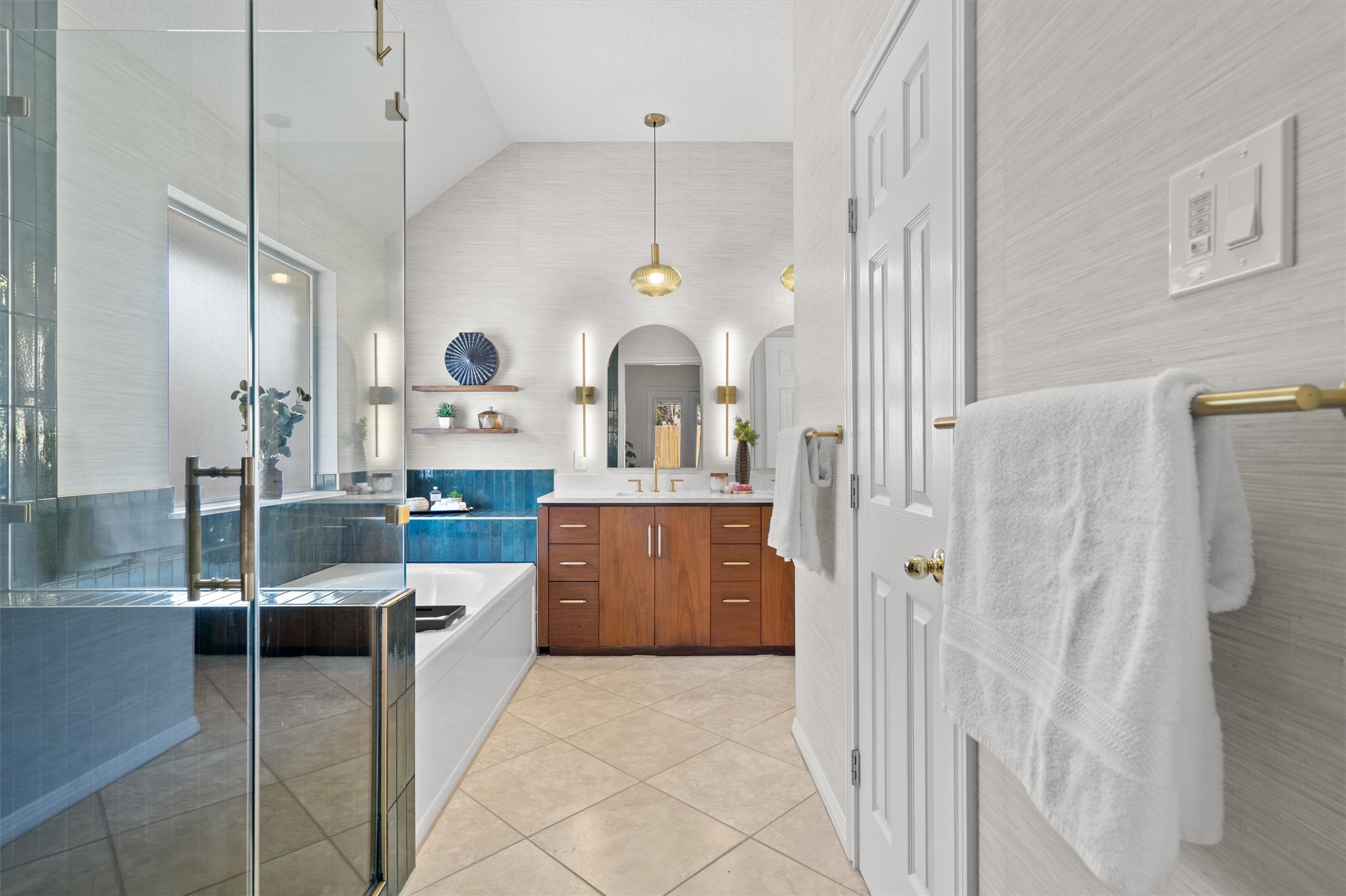 The primary bathroom is a luxurious getaway with an oversized soaking tub, oversized walk-in shower and walnut cabinetry.