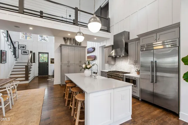 a kitchen with stainless steel appliances granite countertop a refrigerator a stove and a sink with cabinets