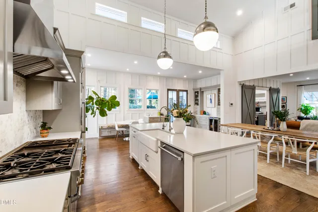 a large kitchen with kitchen island a counter space a sink appliances and cabinets