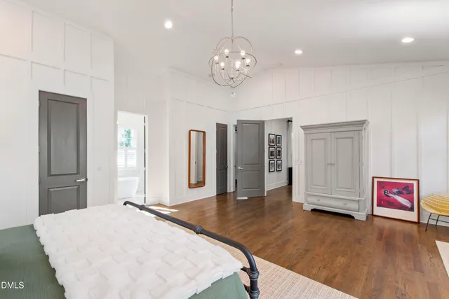 a spacious bedroom with a bed and a chandelier