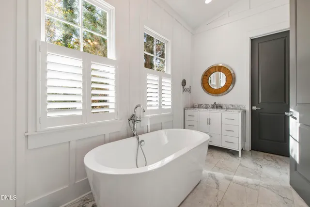 a spacious bathroom with a granite countertop sink and a bathtub