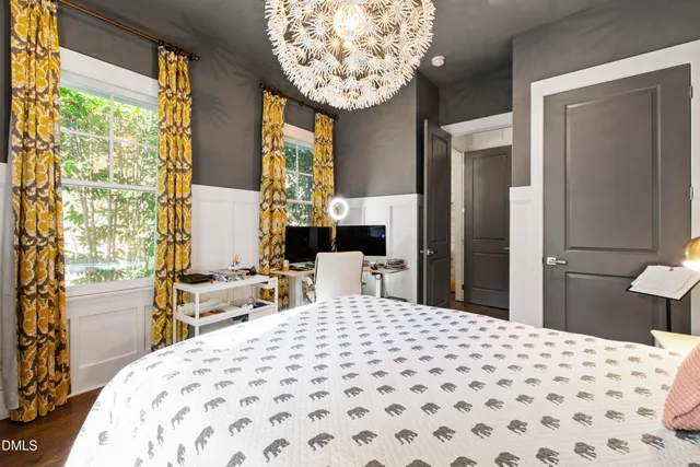 a bedroom with a large bed and a chandelier