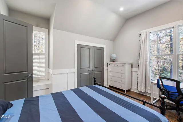 a view of a bedroom with bed and wooden floor