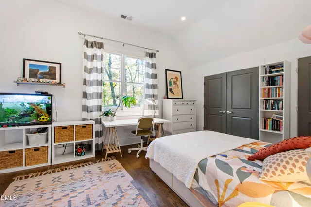a bedroom with a bed a dresser and book shelf