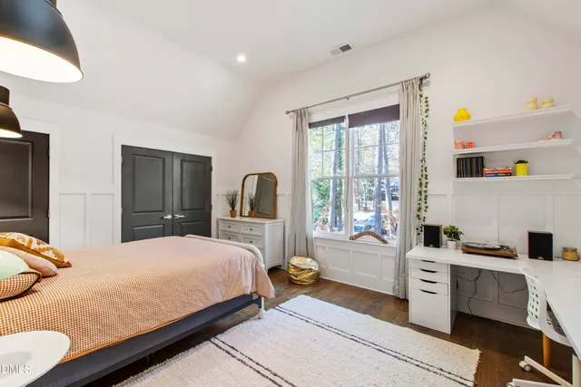 a bedroom with a bed and a large window with the outer view